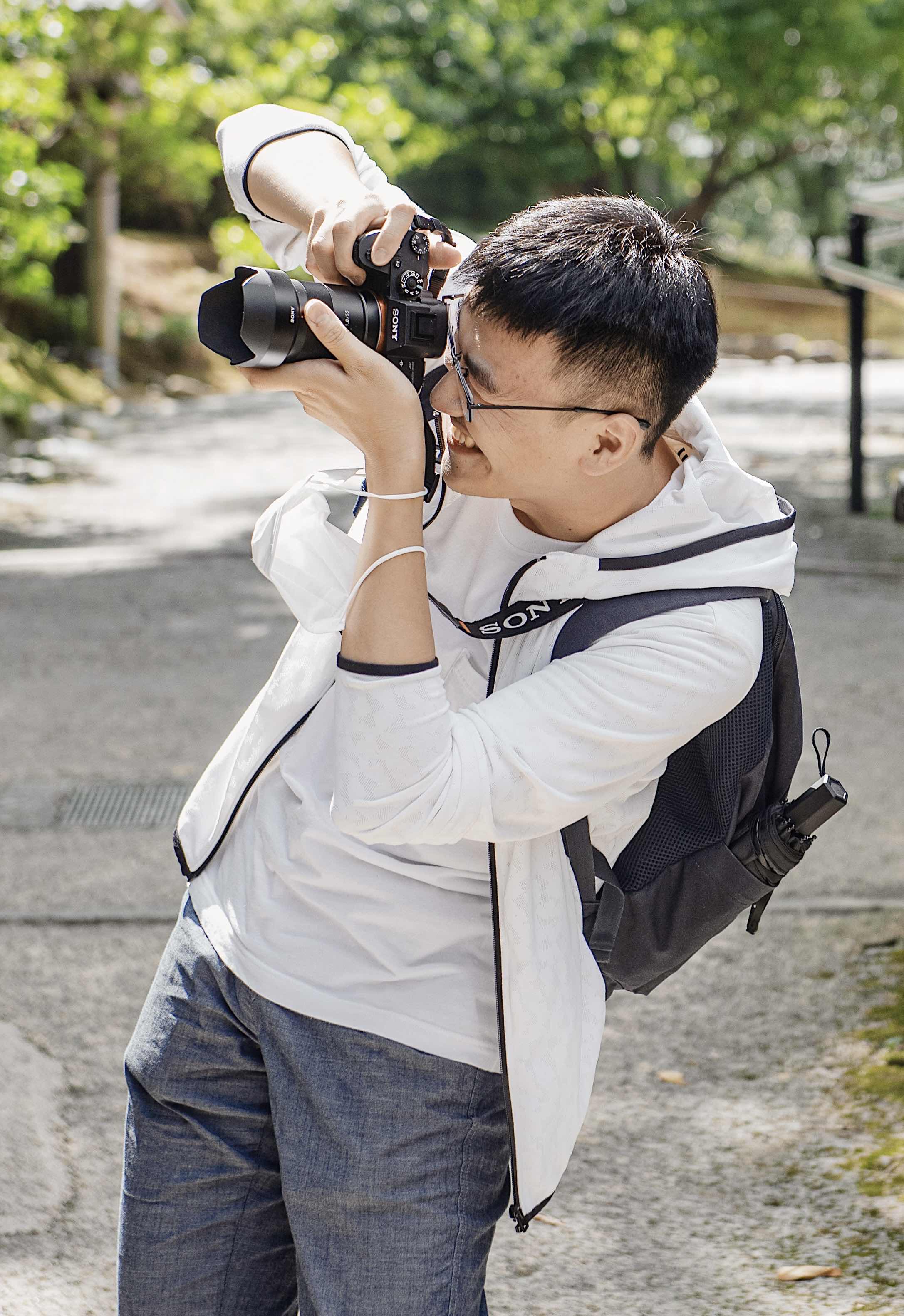 JoeyDDong taking a photograph outdoors.